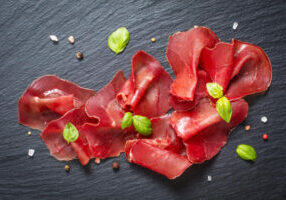Ardoise avec des tranches de bresaola coupées finements
